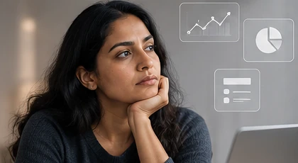A woman, chin on her hand, thinking over charts and figures beside her.